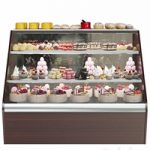Confectionery. Refrigerator with sweets and desserts. Cake