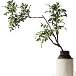Branch with green leaves in an old metal vase